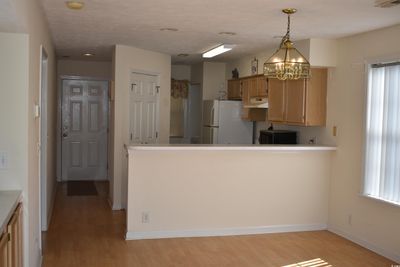 Kitchen featuring light hardwood / wood-style floors, a notable chandelier, decorative light fixtures, and white refrigerator | Image 3