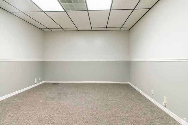 Carpeted empty room with baseboards and a paneled ceiling | Image 12