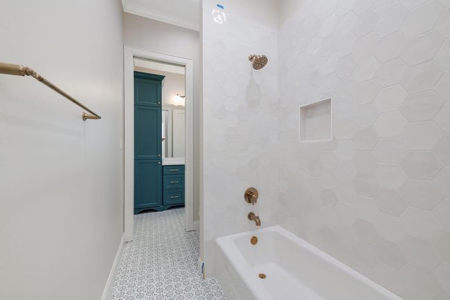 Full bath featuring washtub / shower combination, ornamental molding, and vanity | Image 35