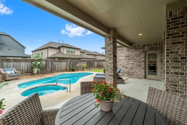 Backyard is an outdoor oasis with a SPARKLING pool, spa and green space. | Image 29