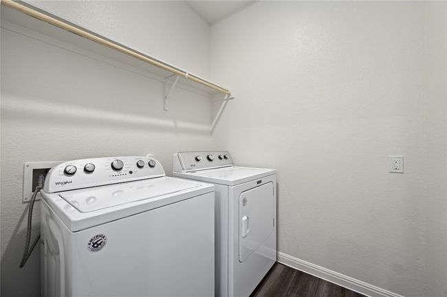 Laundry room featuring washing machine and dryer, baseboards, dark wood-style floors, and laundry area | Image 32