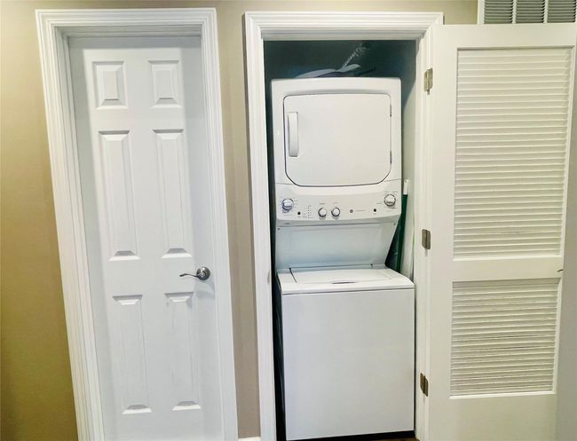 Laundry area with visible vents, stacked washer and clothes dryer, and laundry area | Image 20