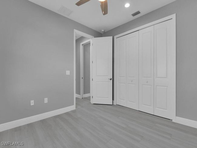 Unfurnished bedroom with wood finished floors, a closet, ceiling fan, and recessed lighting | Image 25