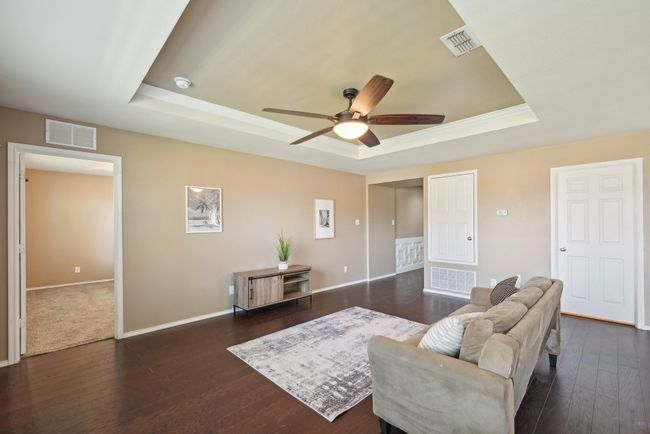 Living area featuring dark wood finished floors, visible vents, and a raised ceiling | Image 8