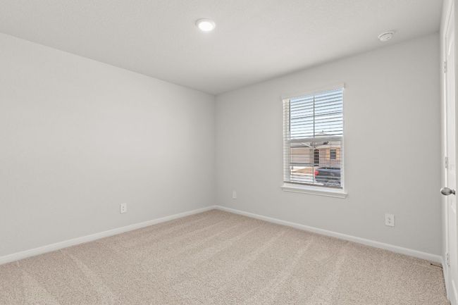 Bedroom featuring carpet flooring, baseboards, and window. | Image 11