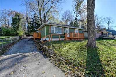 View of front of property with a wooden deck and a front lawn | Image 1