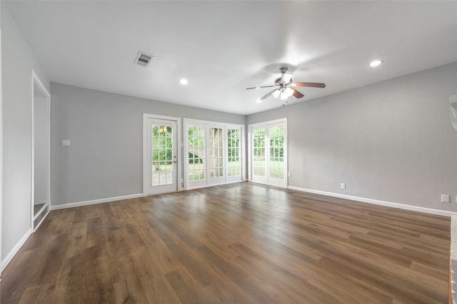 Empty room featuring a ceiling fan, recessed lighting, and dark wood-style floors | Image 35