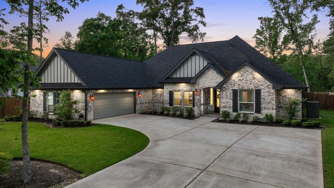 Style and Elegance shine on this single-story brick home with a spacious driveway and two-car garage. Nestled among mature trees and a lush lawn, it offers a private, serene setting. Enjoy a warm, inviting atmosphere with large windows and tasteful exterior lighting. | Image 4