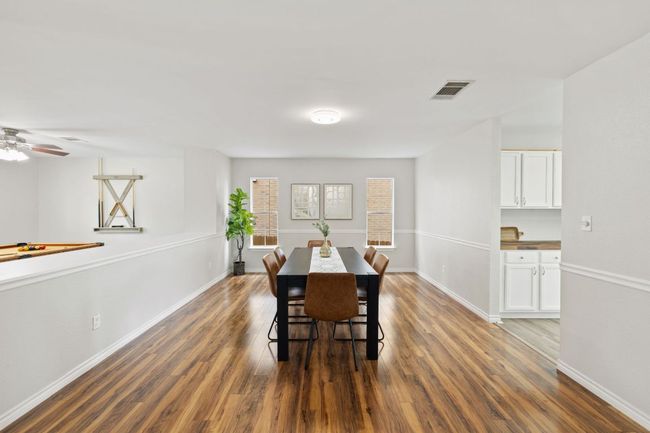 Dining area with dark wood-style flooring, baseboards, and ceiling fan | Image 7