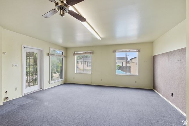 Carpeted empty room with a ceiling fan and baseboards | Image 9