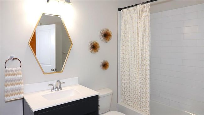 Full bathroom with vanity, shower / bath combo with shower curtain, and toilet | Image 41