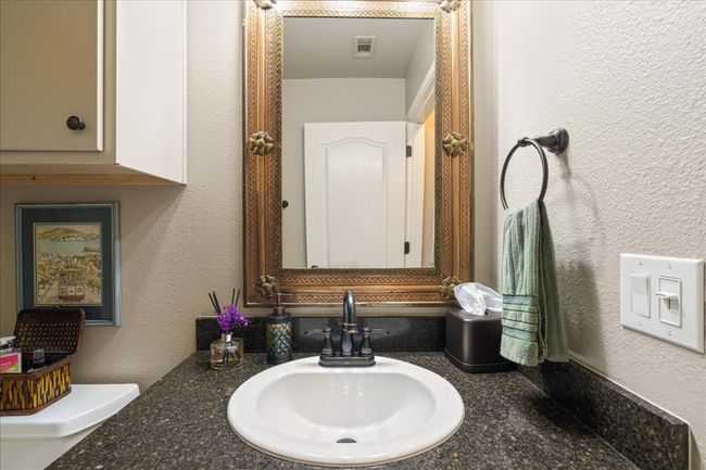 Bathroom featuring vanity, a textured wall, and visible vents | Image 33