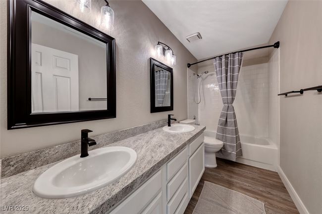 Full bath featuring shower / tub combo with curtain, double vanity, and wood finished floors | Image 28