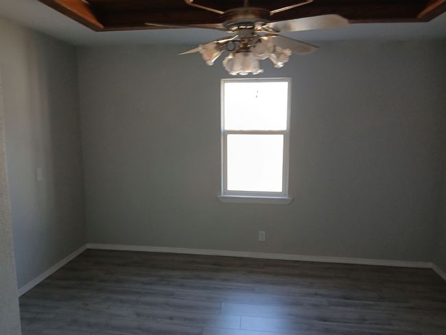 Empty room with dark hardwood / wood-style flooring and ceiling fan | Image 12