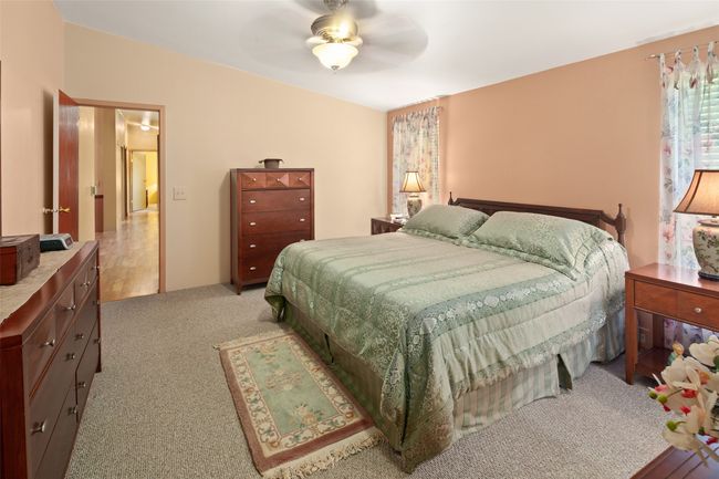Bedroom with light colored carpet and ceiling fan | Image 21