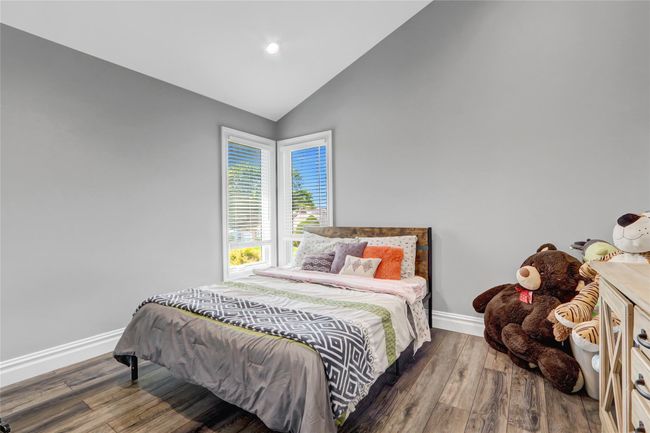 Bedroom with baseboards, wood finished floors, recessed lighting, and high vaulted ceiling | Image 20