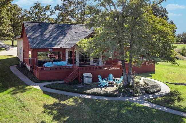 Rear view of house featuring a fire pit, a lawn, and central AC | Image 27