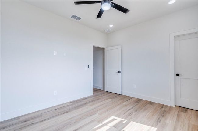 Empty room with a ceiling fan, light wood finished floors, and recessed lighting | Image 27