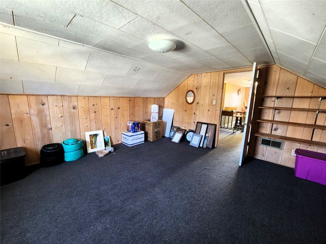 Additional living space with lofted ceiling, visible vents, wood walls, and carpet floors | Image 35