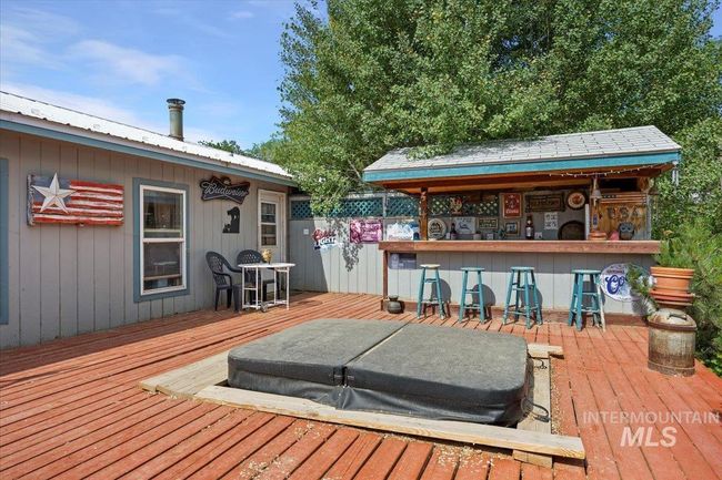 Wooden deck featuring a covered hot tub | Image 10