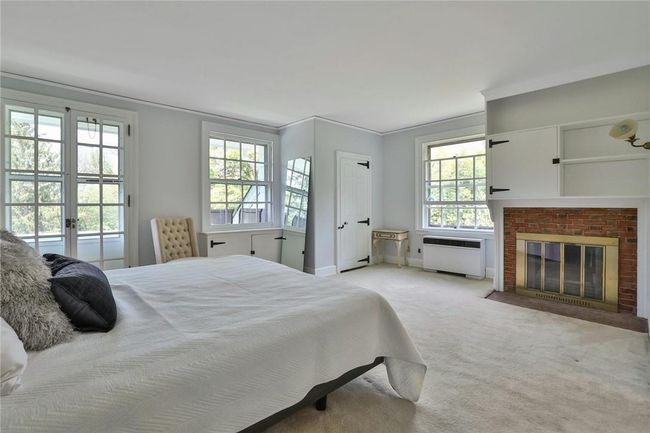 Light filled corner accented by a brick fireplace, ornamental moldings and ensuite bath | Image 21