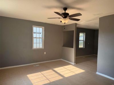 Spare room with ceiling fan and a healthy amount of sunlight | Image 3