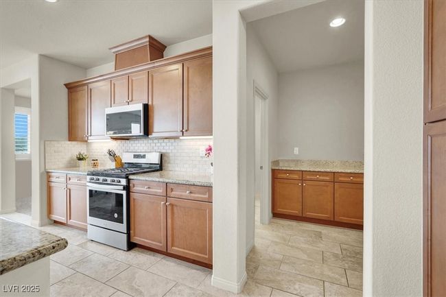 Kitchen featuring appliances with stainless steel finishes, decorative backsplash, recessed lighting, and light stone countertops | Image 20