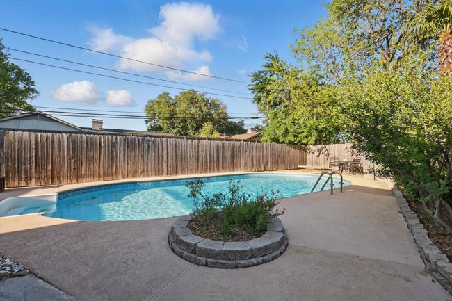 View of swimming pool featuring a fenced backyard, a fenced in pool, and a patio | Image 31