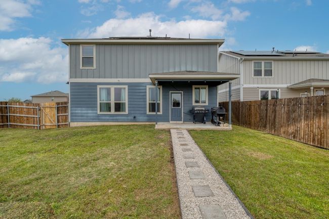Back of house with a fenced backyard, a lawn, a patio, and board and batten siding | Image 31