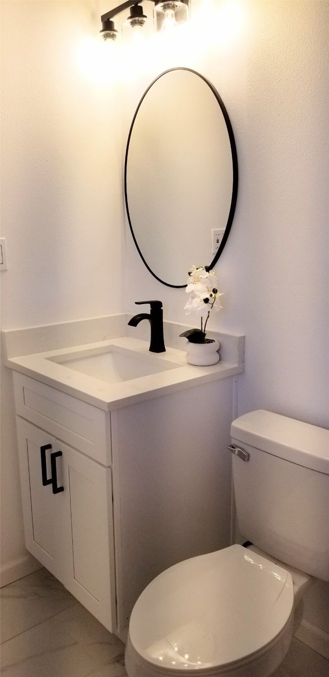 Half bathroom with vanity, toilet, and marble look tiles | Image 24
