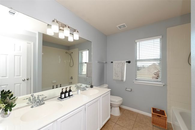 Bathroom with visible vents, a sink, toilet, and tile patterned floors | Image 17