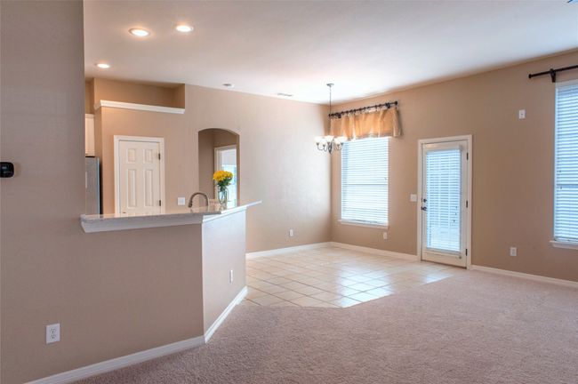 Unfurnished living room featuring light tile patterned floors, arched walkways, recessed lighting, light colored carpet, and baseboards | Image 6