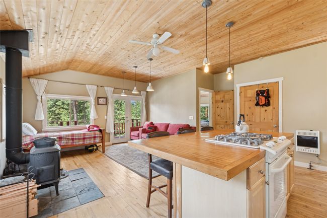 Apartment kitchen with heating unit, stove, a wood stove, open floor plan, and wooden counters | Image 50