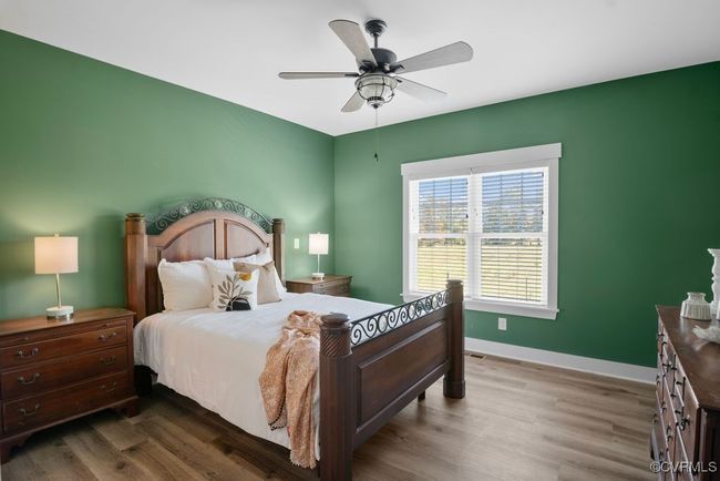 Bedroom with ceiling fan, baseboards, and wood finished floors | Image 14