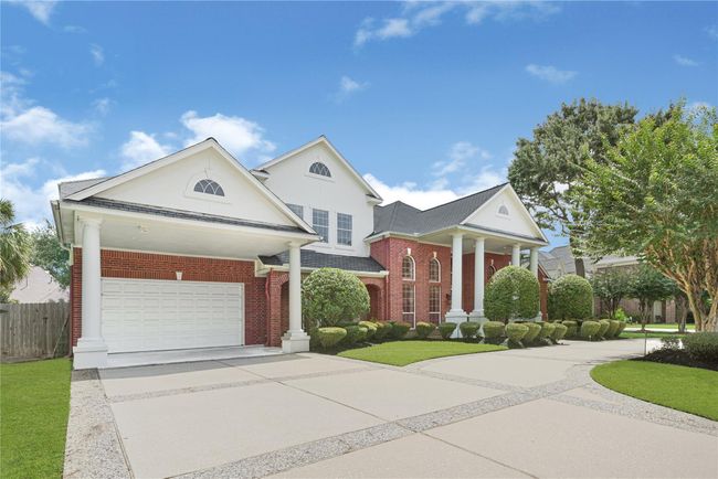 This is spacious four-car garage, and a wide driveway offers ample parking space. | Image 4