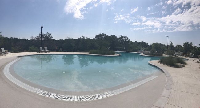 Community pool featuring a patio area and a wooded view | Image 12