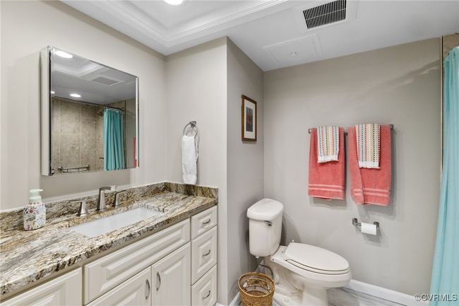 Full bathroom featuring a shower with shower curtain, toilet, vanity, baseboards, and visible vents | Image 12