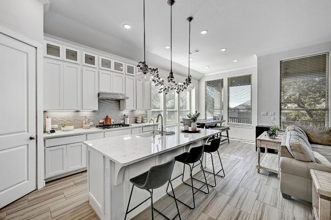 The chef’s kitchen features a large center island and breakfast bar, providing plenty of space for meal prep and casual dining. | Image 6