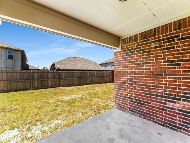 Fenced backyard with a patio | Image 35