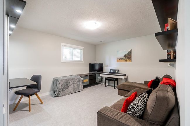 Living room with carpet flooring, a textured ceiling, and baseboards | Image 25