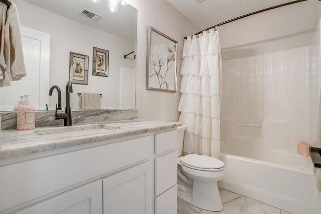 Bathroom featuring vanity, marble look tiles, and shower / bathtub combination with curtain | Image 28