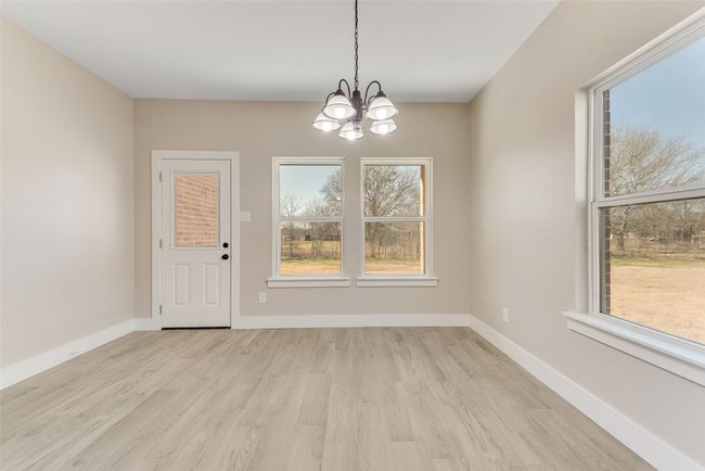 Unfurnished dining area with light wood-style flooring and a chandelier | Image 17