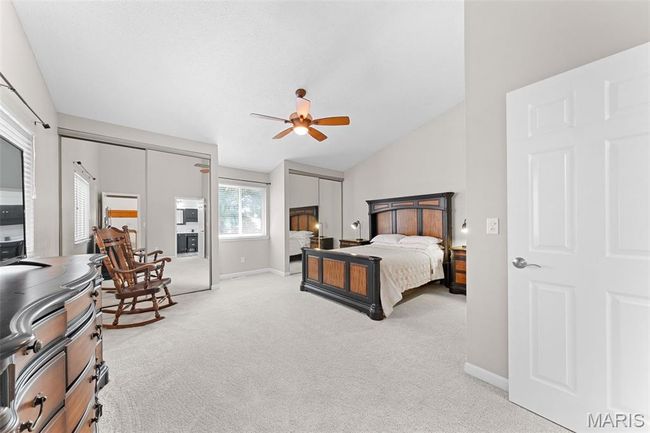 Primary suite featuring new carpet, vaulted ceiling, a ceiling fan, and multiple closets | Image 10