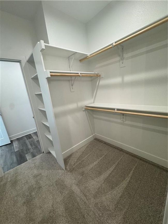 Spacious closet with dark colored carpet | Image 21
