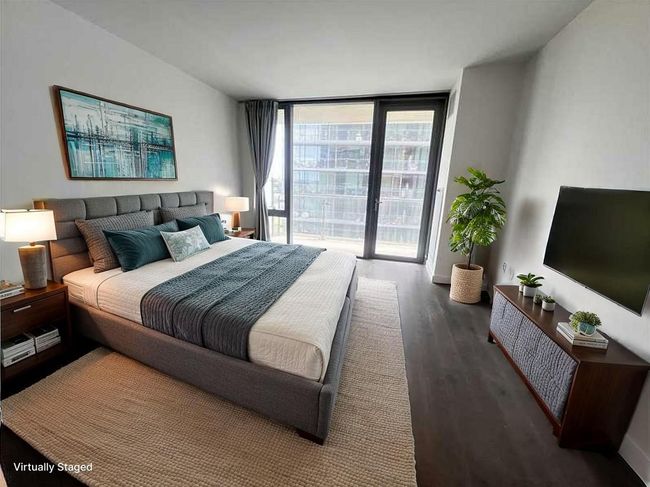 Bedroom with a wall of windows, wood finished floors, and access to outside | Image 5