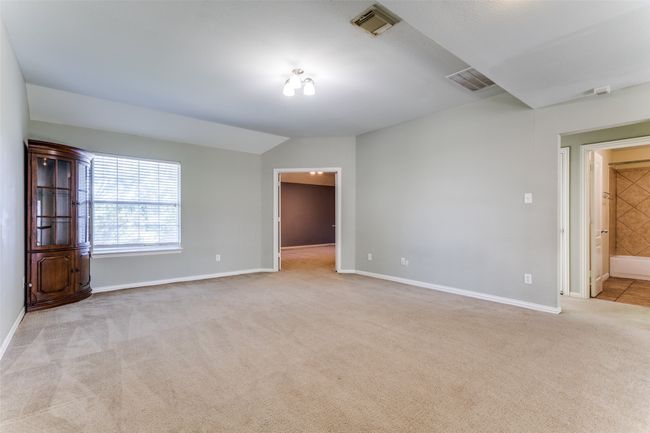 Carpeted empty room with baseboards and lofted ceiling | Image 19