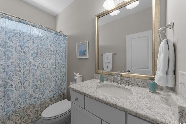 Bathroom featuring vanity, toilet, and a shower with curtain | Image 24