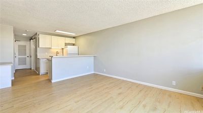 Living Room view towards new kitchen and built-in desk. Note: Walls have been refinished (smoothed). | Image 1