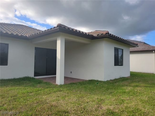 Back of house featuring a lawn, a patio, stucco siding, and a tile roof | Image 35