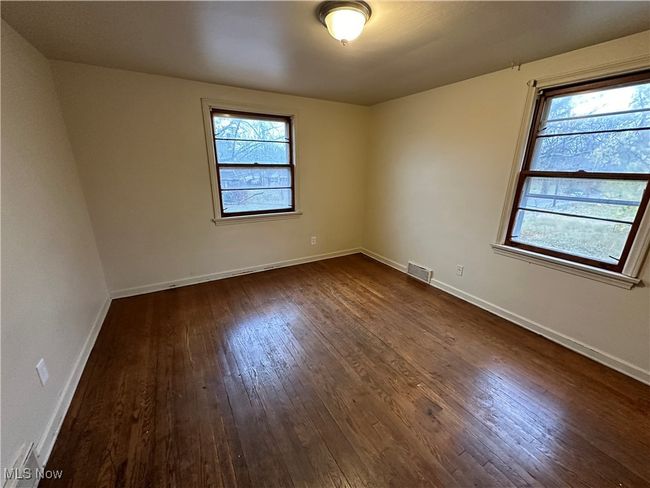 Unfurnished room featuring visible vents, dark wood-style floors, and baseboards | Image 5